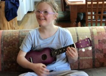 Miss Zee, 12, enjoying playing the ukelele. Hearing practitioners can help close the gap in life expectancy for people with intellectual disabilities. Image: Dani Fox.