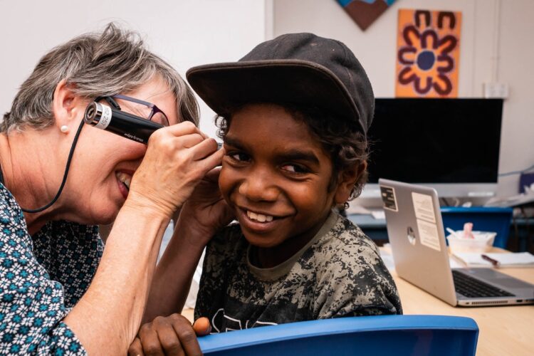 Earbus co-founder, nurse audiometrist Dee Parker checking a child's ears. Image: Earbus.