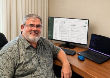 Gold Coast audiologist Christo Fourie working on the new AudZone Customer Relationship Management (CRM) system. Image: Christo Fourie.